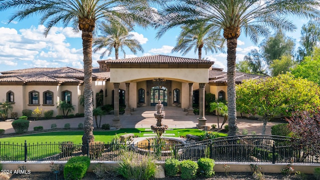 back of property with a lawn and french doors