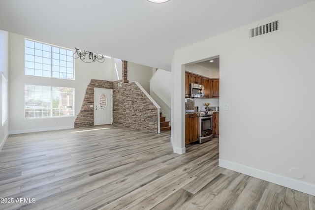 31259 N 42nd Pl, Cave Creek, AZ 85331 - unfurnished living room featuring stairway, light wood-style flooring, a chandelier, and a high ceiling