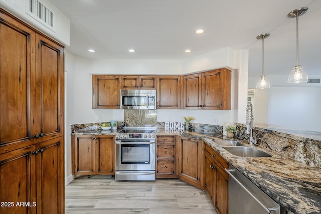 31259 N 42nd Pl, Cave Creek, AZ 85331 - kitchen with stainless steel appliances, brown cabinets, light wood-style flooring, dark stone counters, and recessed lighting