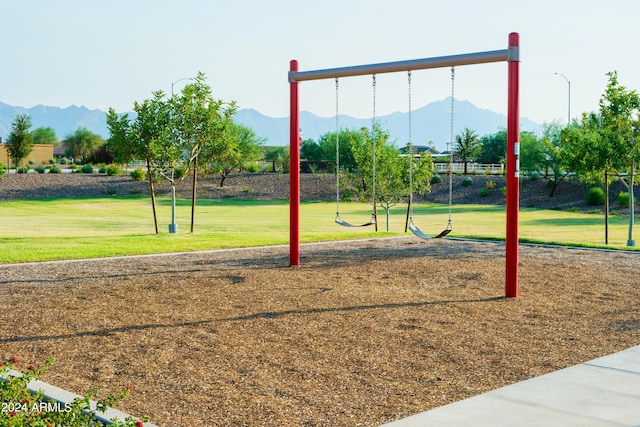 view of jungle gym with a mountain view and a yard