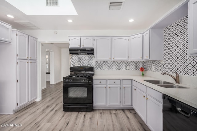 kitchen featuring black appliances, white cabinets, light wood-type flooring, and sink