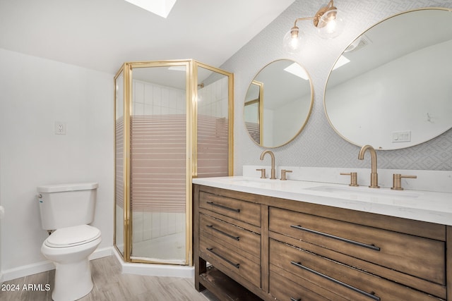 bathroom featuring hardwood / wood-style flooring, vanity, a shower with shower door, and toilet