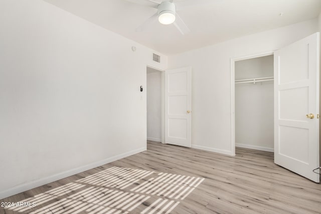 unfurnished bedroom featuring ceiling fan, a closet, and light hardwood / wood-style flooring