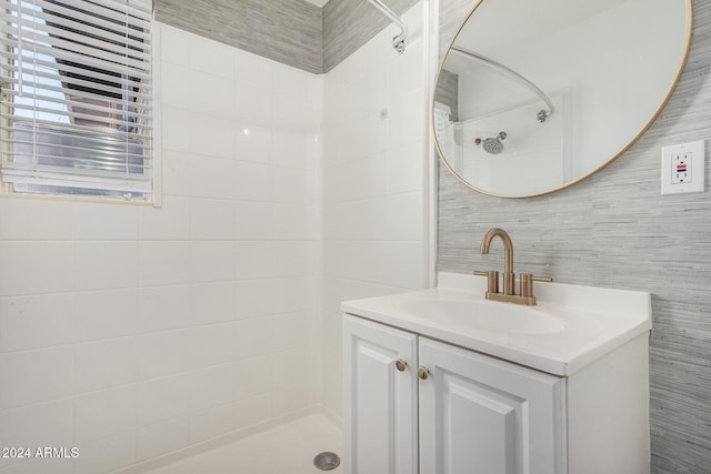 bathroom with vanity, a shower, and tile walls