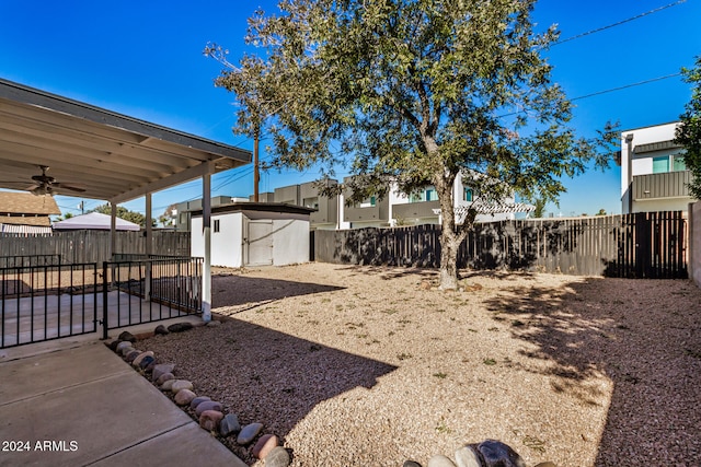 view of yard with ceiling fan and a storage shed