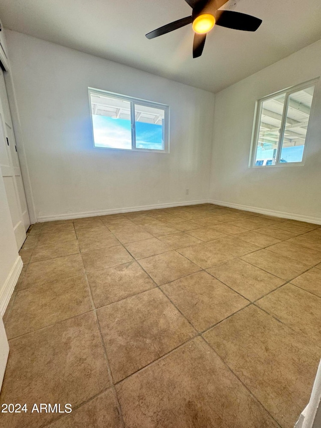 spare room featuring ceiling fan and light tile floors