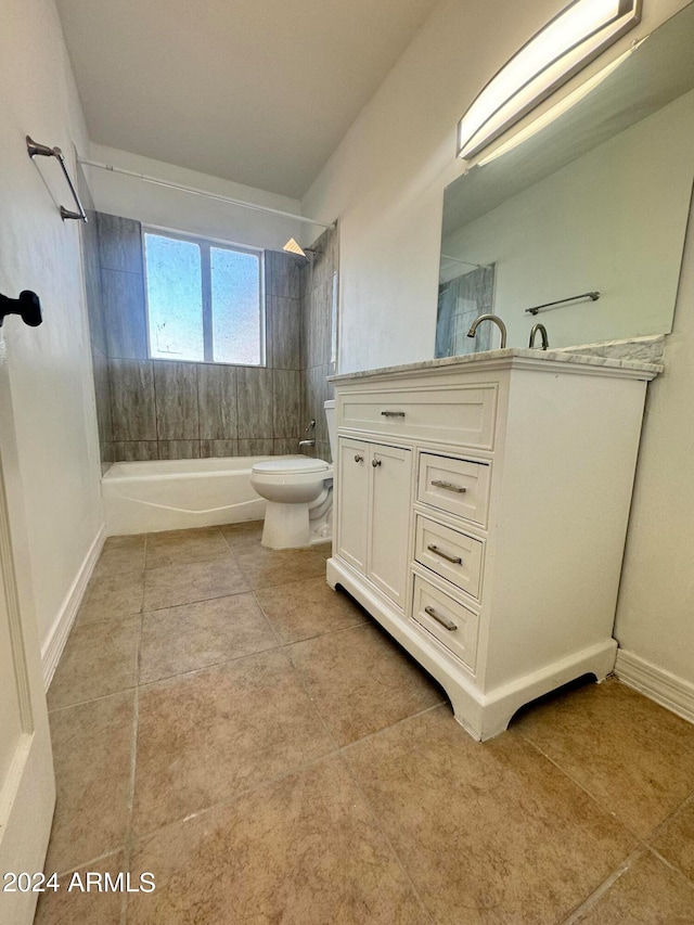 full bathroom with tile floors, toilet, vanity, and tiled shower / bath