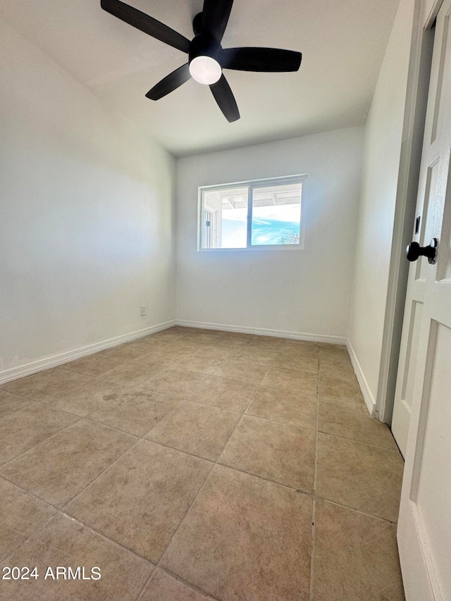 spare room featuring ceiling fan and light tile floors