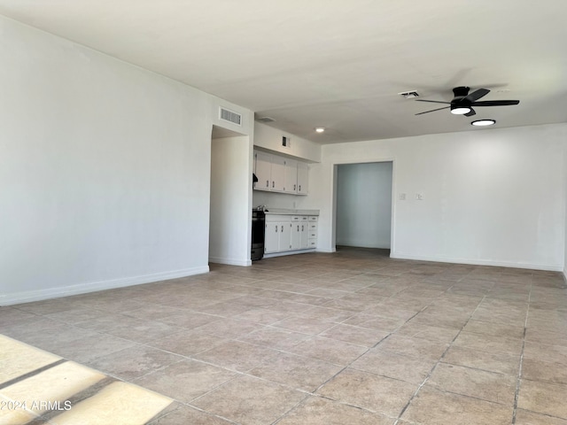 unfurnished living room with ceiling fan and light tile floors