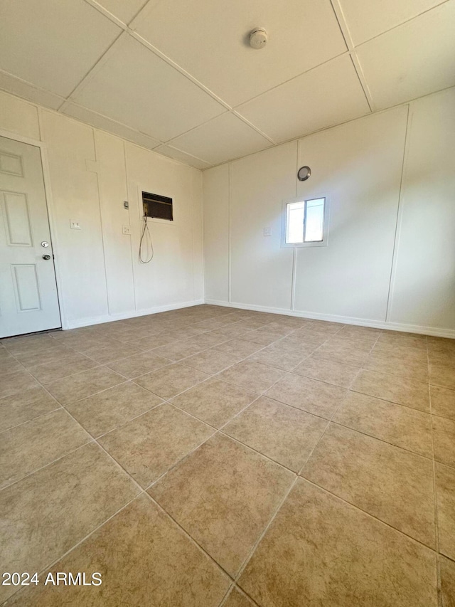 tiled spare room with a paneled ceiling