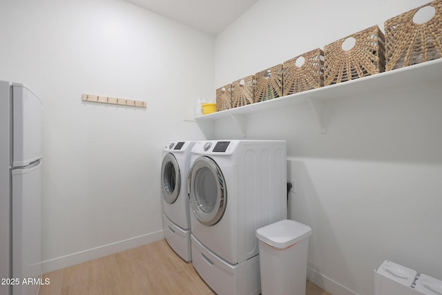 washroom with washer and dryer and light hardwood / wood-style floors