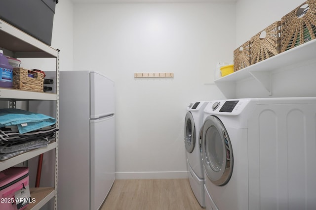 laundry area featuring light wood-type flooring and independent washer and dryer