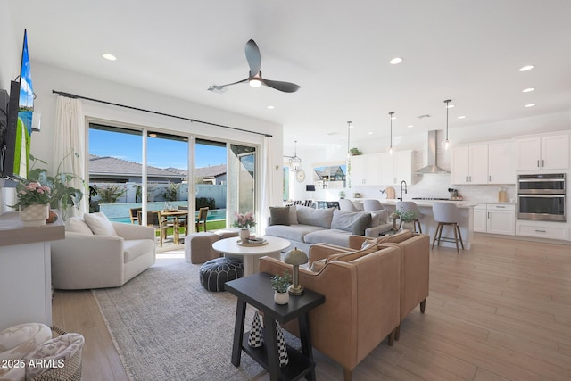 living room featuring ceiling fan and light hardwood / wood-style flooring