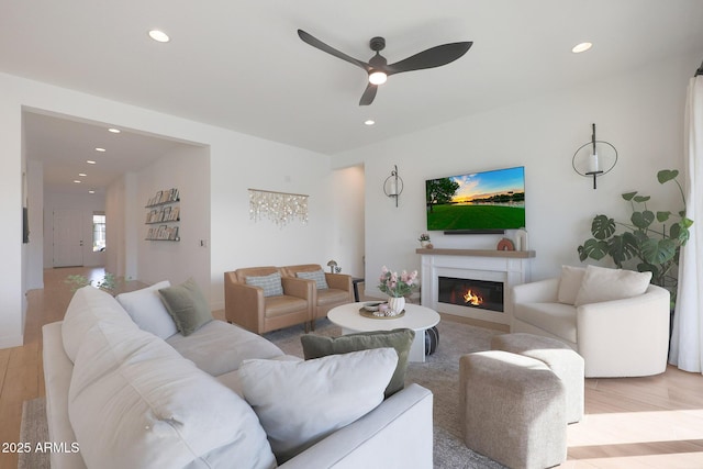 living room featuring light hardwood / wood-style flooring and ceiling fan