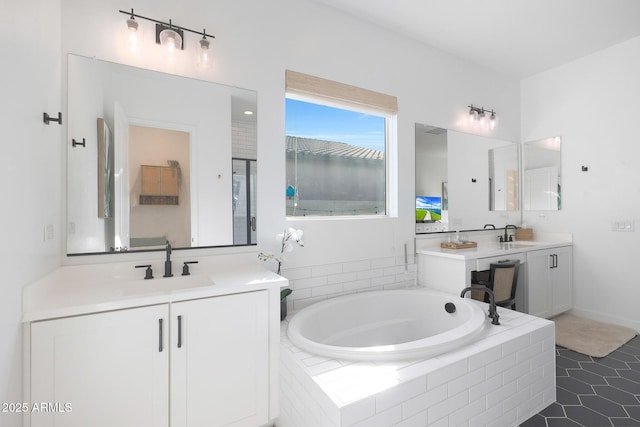 bathroom featuring tiled tub, vanity, and tile patterned floors