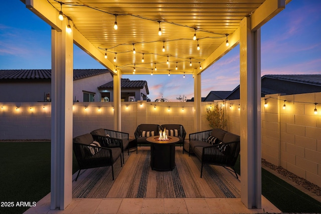 patio terrace at dusk featuring an outdoor living space with a fire pit