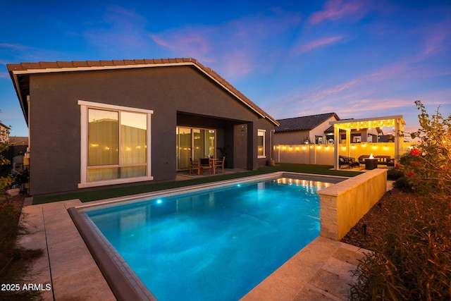 pool at dusk featuring a patio area