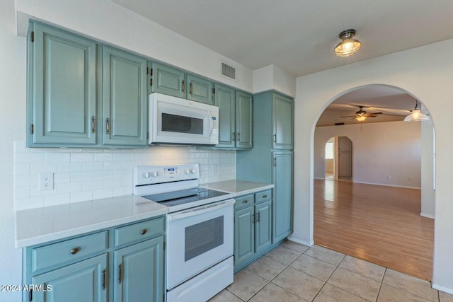 kitchen featuring ceiling fan, light hardwood / wood-style floors, white appliances, and backsplash