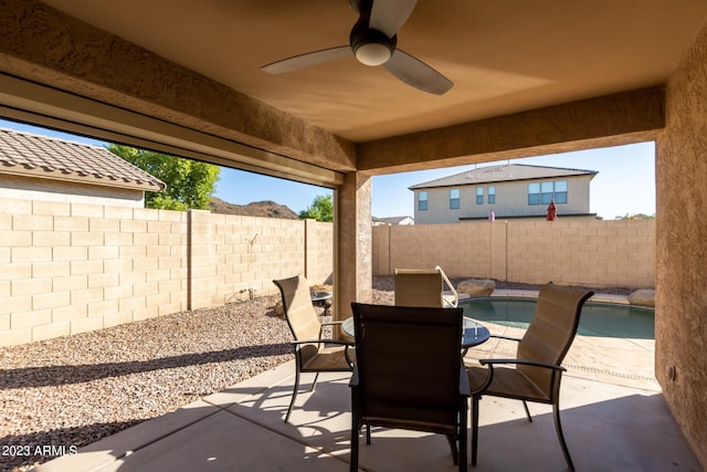 view of patio / terrace featuring outdoor dining area, a fenced backyard, a fenced in pool, and a ceiling fan