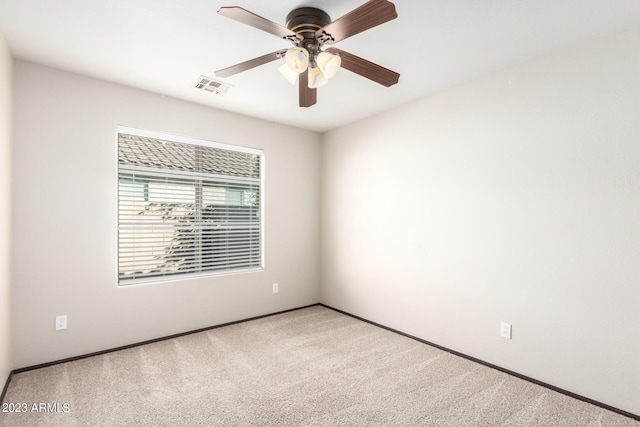 carpeted spare room with ceiling fan, baseboards, and visible vents