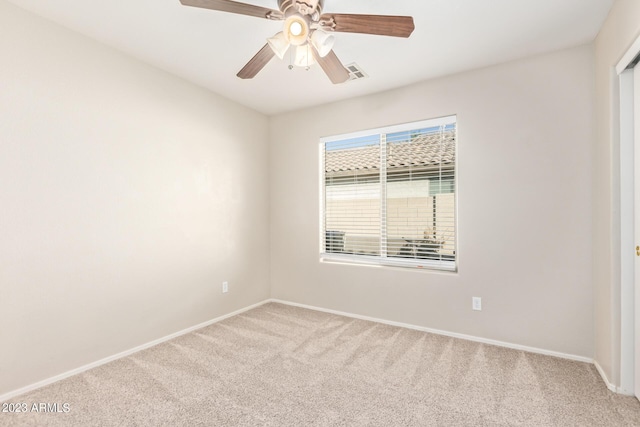 spare room with carpet flooring, visible vents, baseboards, and ceiling fan
