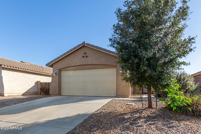 view of front of house featuring concrete driveway, stucco siding, a tiled roof, and an attached garage