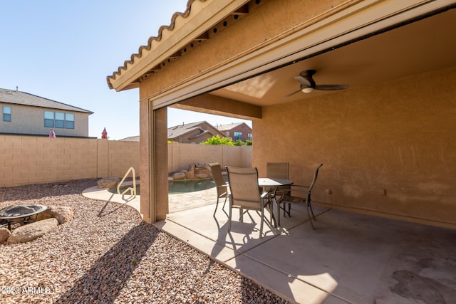view of patio / terrace featuring an outdoor fire pit, outdoor dining space, a ceiling fan, and fence private yard