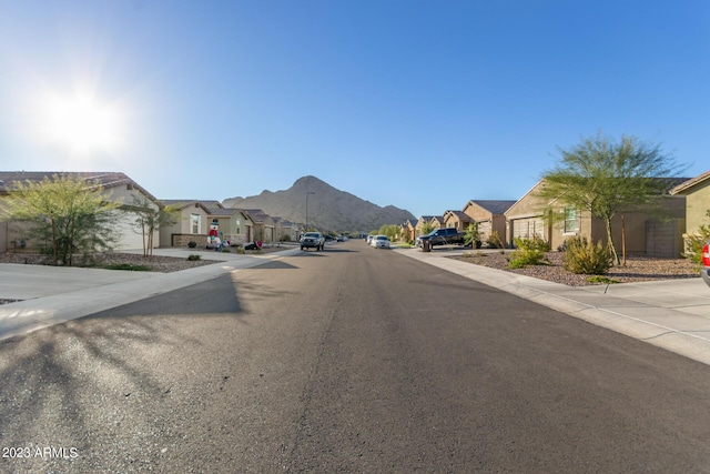 view of road with sidewalks, a mountain view, and a residential view