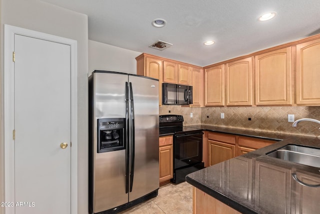 kitchen featuring light brown cabinets, a sink, backsplash, and black appliances