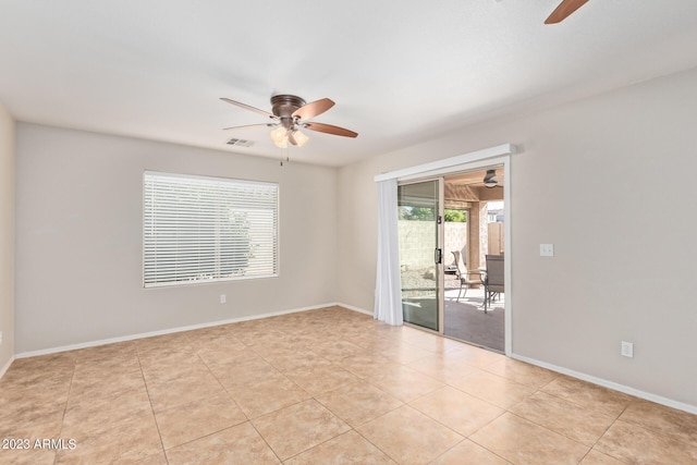 empty room featuring visible vents, ceiling fan, light tile patterned flooring, and baseboards
