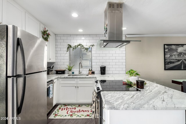 kitchen featuring white cabinets, wall chimney range hood, crown molding, light stone countertops, and appliances with stainless steel finishes