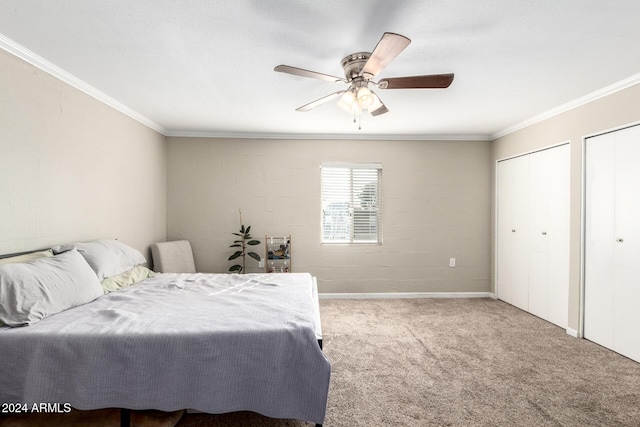 bedroom featuring ceiling fan, light colored carpet, crown molding, and multiple closets