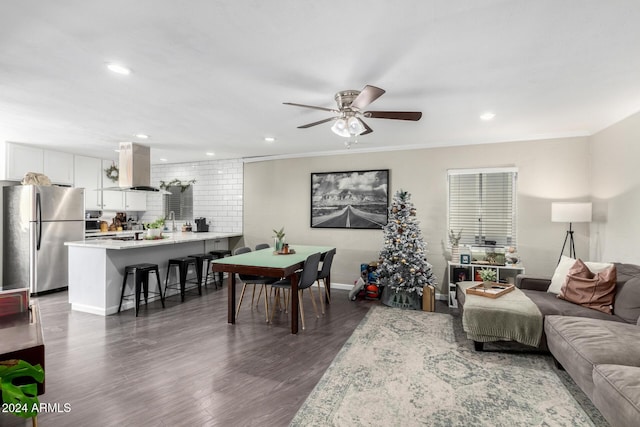 living room with dark hardwood / wood-style floors, ceiling fan, and crown molding