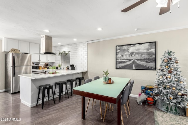 dining room with ornamental molding, ceiling fan, dark wood-type flooring, and sink