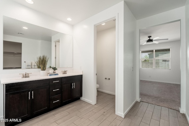 17652 W Fetlock Trl, Surprise, AZ 85387 - bathroom featuring wood tiled floors, double vanity, ceiling fan, and recessed lighting