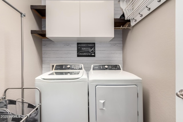 washroom with cabinets and washing machine and dryer