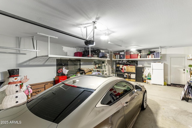 garage with a garage door opener and white fridge