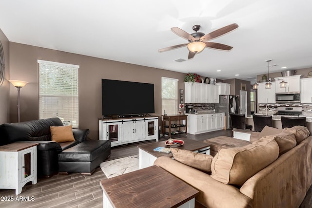 living room featuring ceiling fan and light hardwood / wood-style flooring