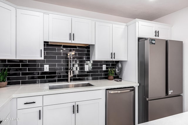 kitchen with white cabinets, decorative backsplash, sink, and stainless steel appliances