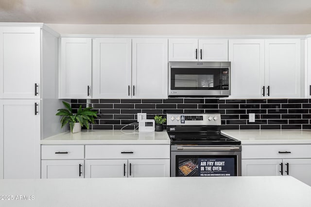 kitchen with white cabinetry, appliances with stainless steel finishes, and tasteful backsplash