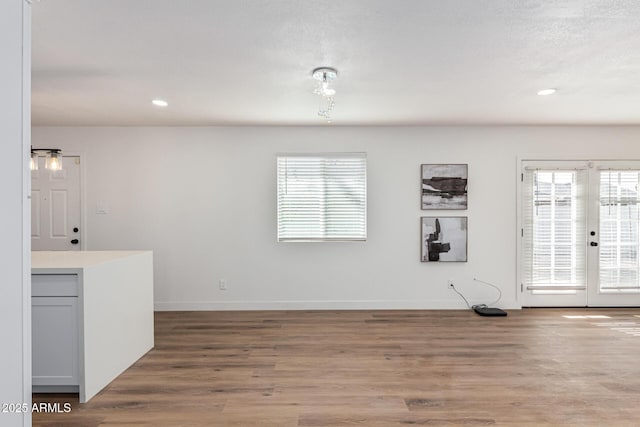 interior space featuring hardwood / wood-style floors, a textured ceiling, and french doors