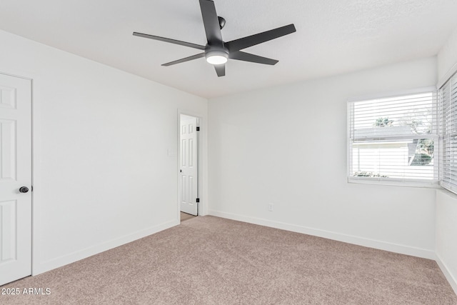 spare room with ceiling fan and light colored carpet