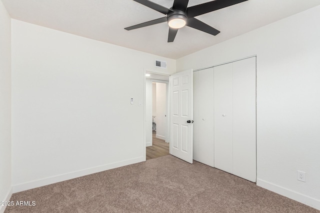 unfurnished bedroom with light carpet, a closet, and ceiling fan