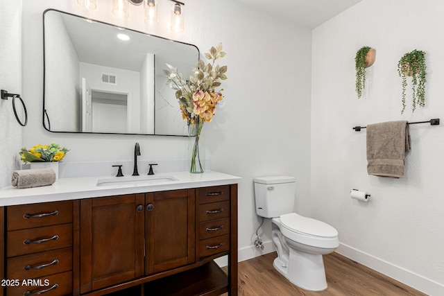 bathroom with hardwood / wood-style flooring, vanity, and toilet