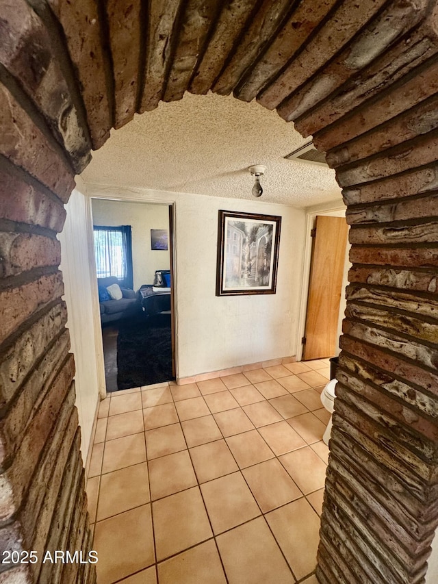 interior space with light tile patterned flooring and a textured ceiling