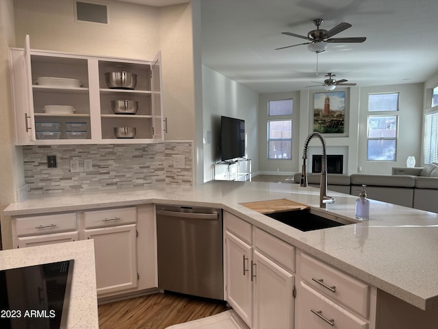 kitchen with light stone countertops, sink, light hardwood / wood-style floors, stainless steel dishwasher, and white cabinets