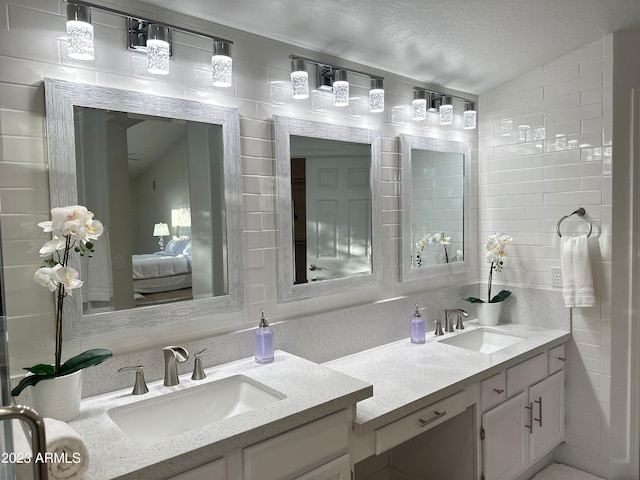 bathroom featuring vanity, a textured ceiling, and lofted ceiling