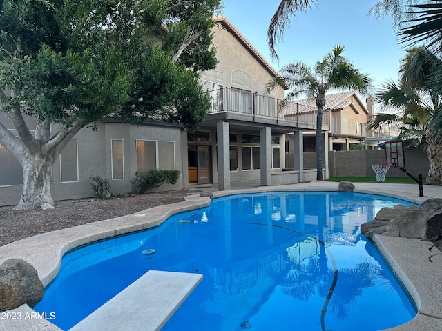 view of swimming pool featuring a diving board