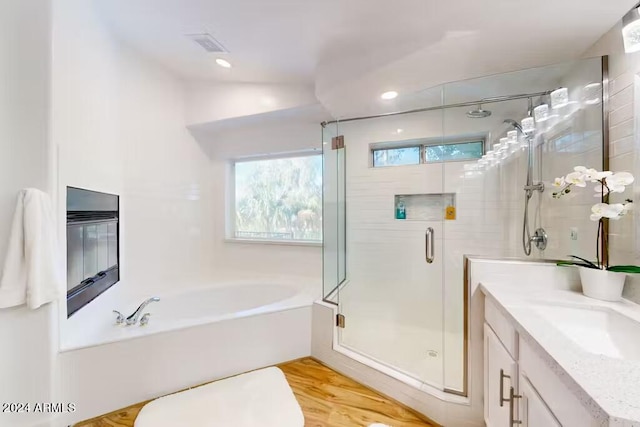 bathroom with vanity, hardwood / wood-style flooring, and plus walk in shower