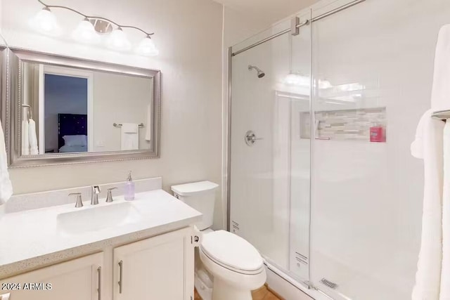 bathroom featuring vanity, toilet, and walk in shower